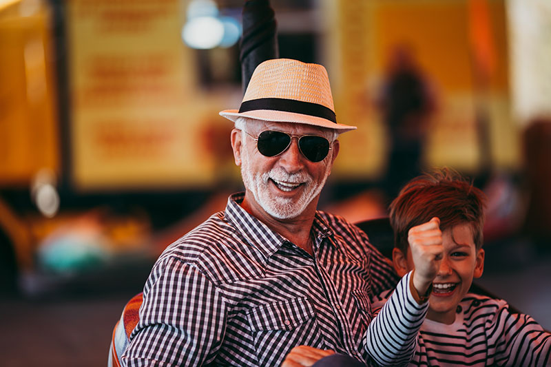older man and child at an amusement park